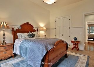 A bedroom with a bed , nightstand , lamps and a rug.