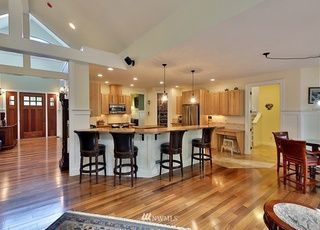 A kitchen with a bar and stools in a large house.
