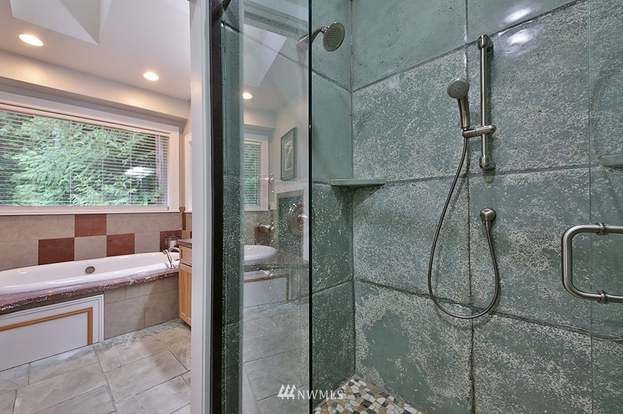 A bathroom with a walk in shower and a bathtub.