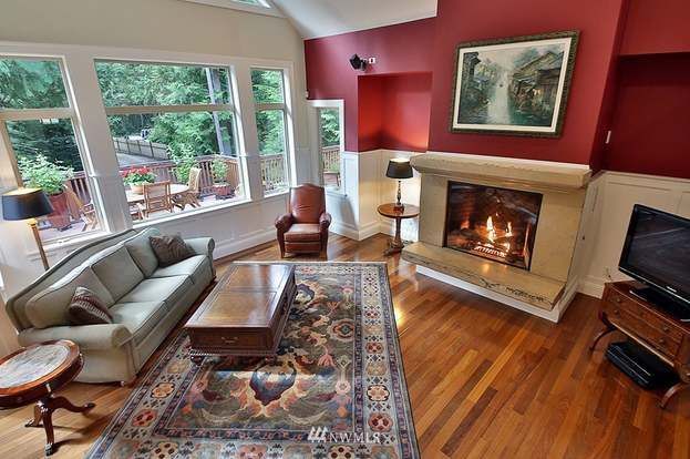 A living room with a fireplace , couch , chair and television.