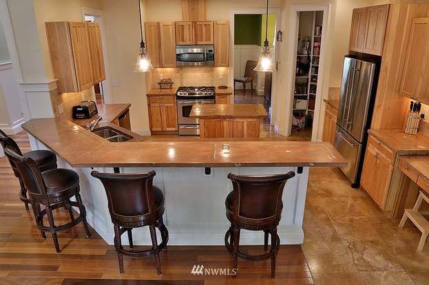 A kitchen with a bar and stools in it.