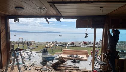 A man is working in a room with a view of the ocean