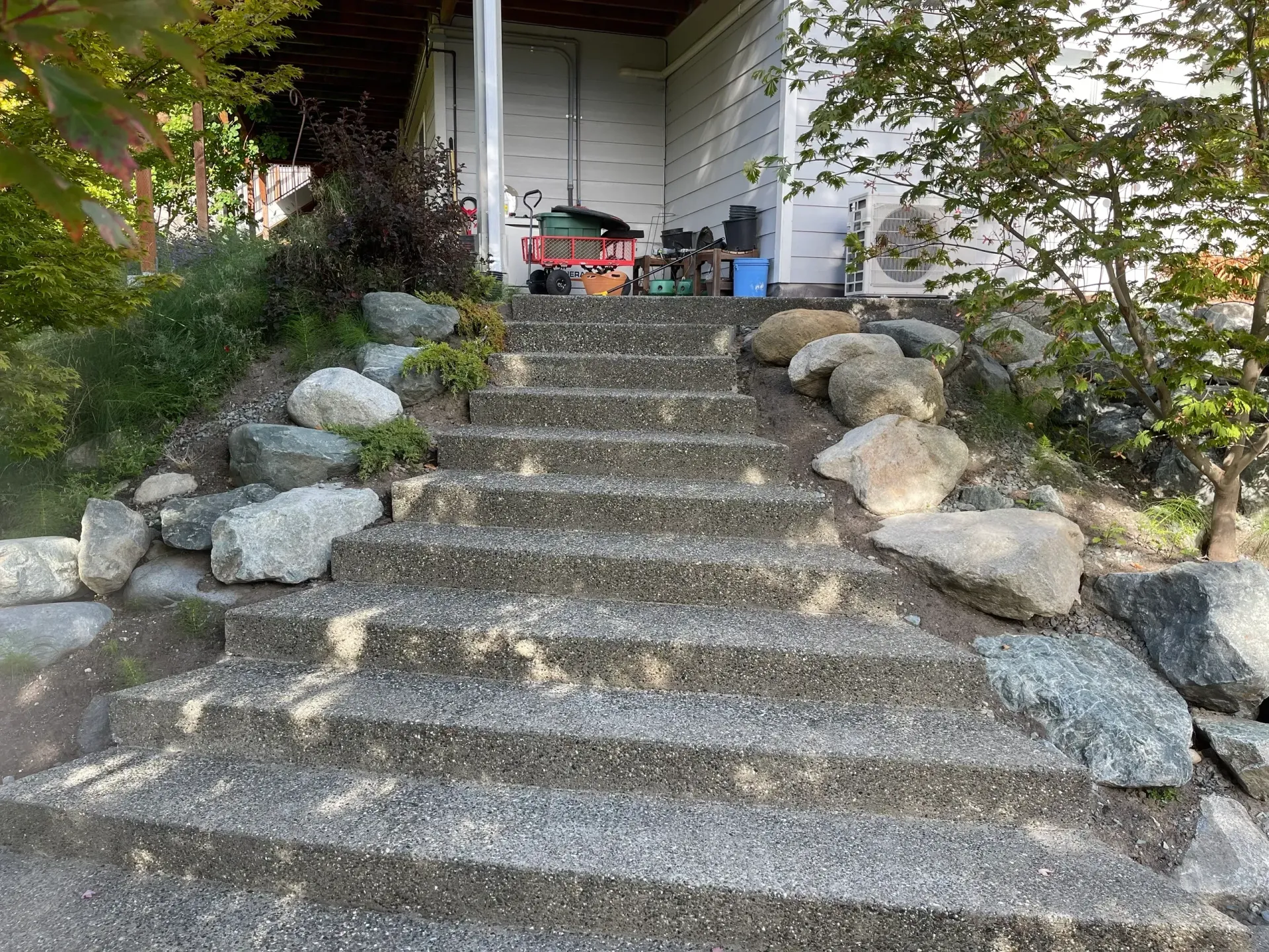 A set of stairs leading up to a house surrounded by rocks.