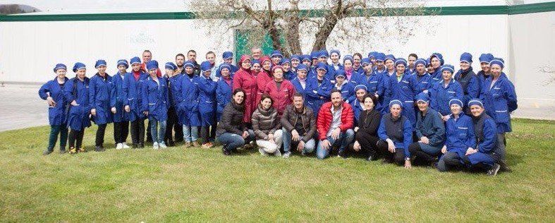 Un gruppo di persone in uniforme blu posa sull'erba, alcune inginocchiate.