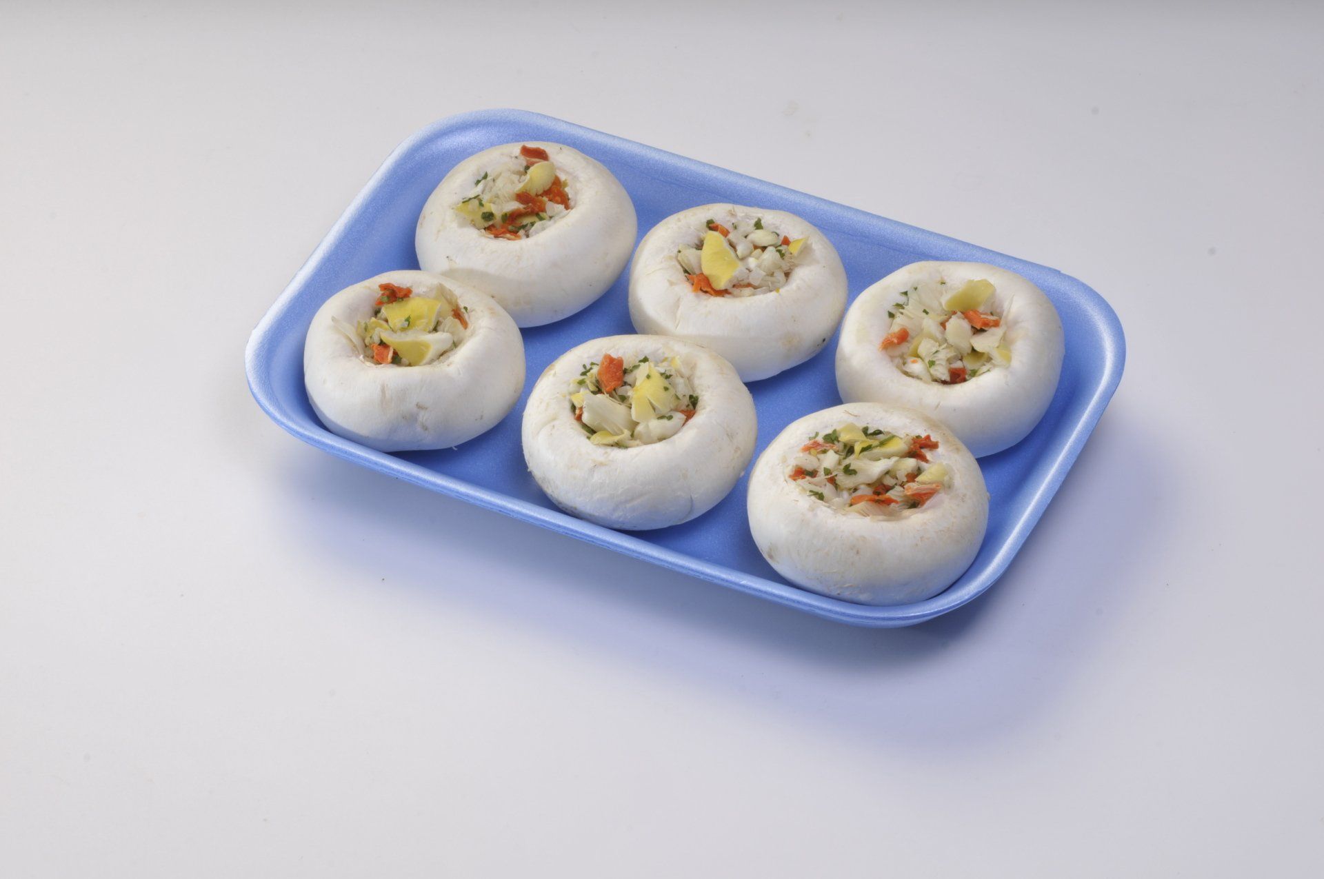 Sei panini bianchi ripieni di ripieno colorato su un vassoio blu.