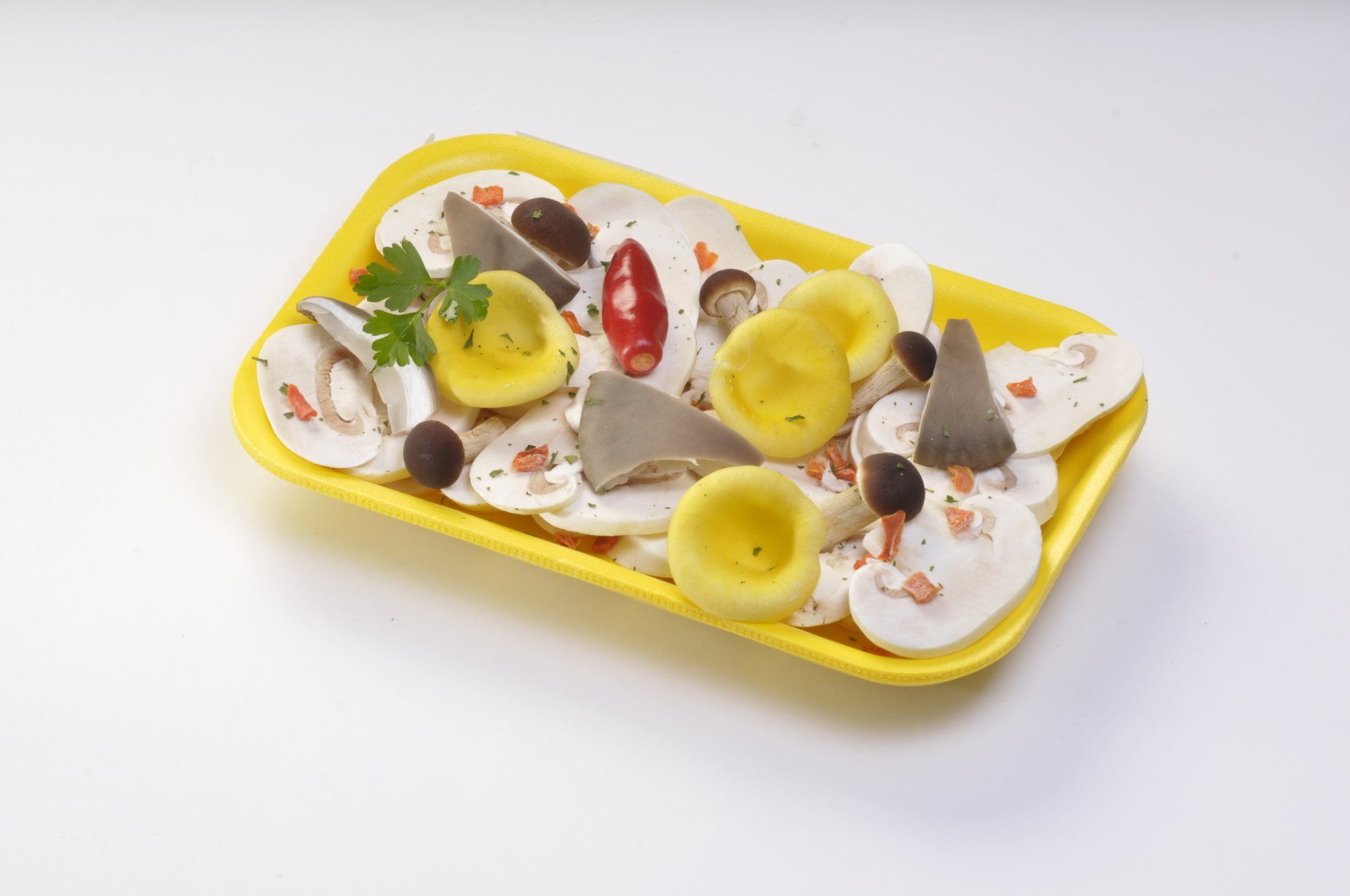 Funghi e altri ingredienti su un vassoio giallo.