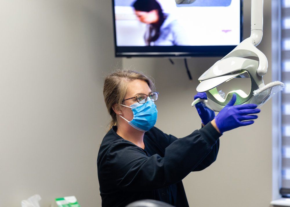 Tooth Removal — Assistant Using Lamp in Jasper, IN