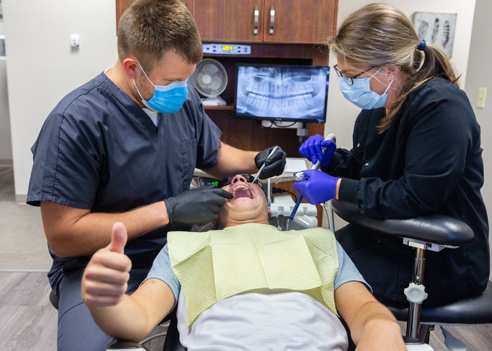 Gum Disease Treatment — Teenager Doing Thumbs Up While Cleaning Teeth in Jasper, IN