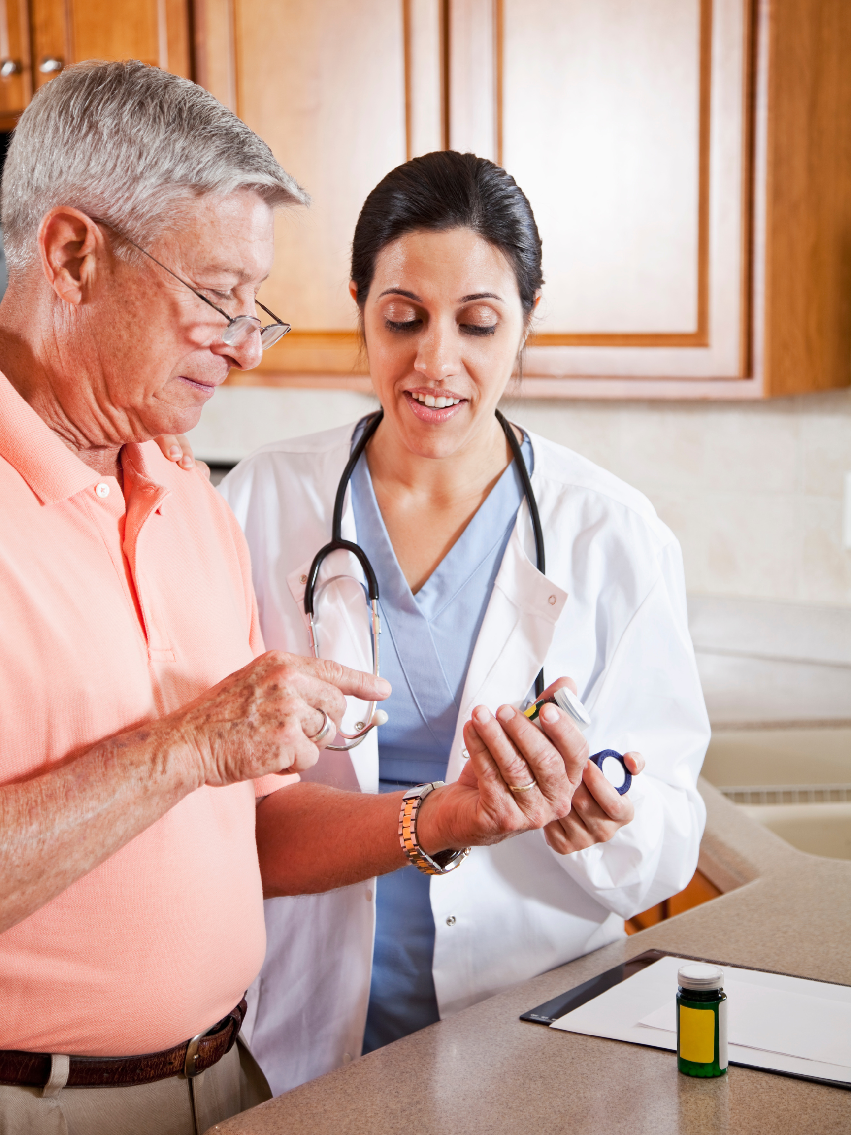 A doctor is giving an elderly man a bottle of pills