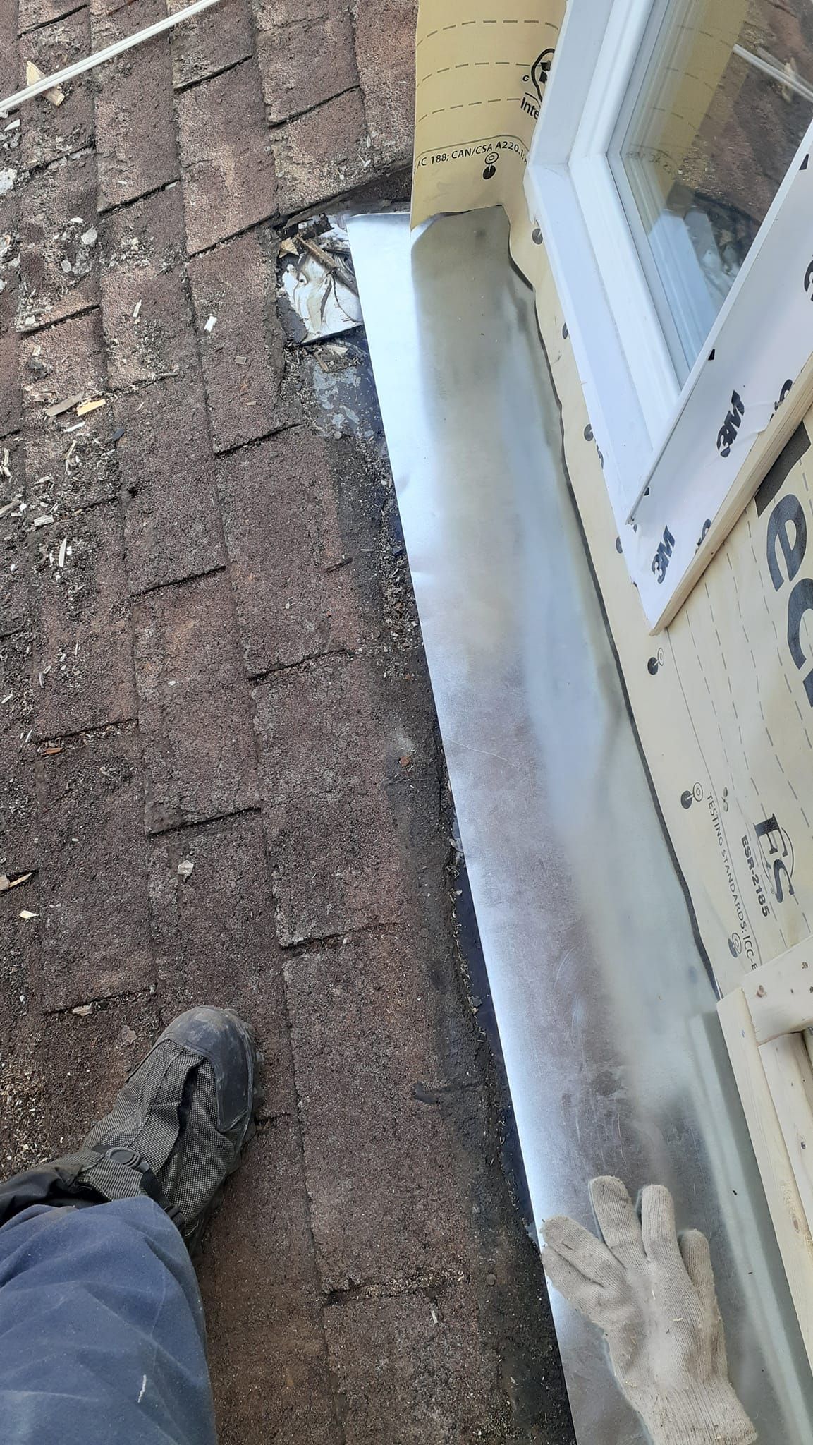 Une personne coupe un morceau de métal sur le côté d'un bâtiment.