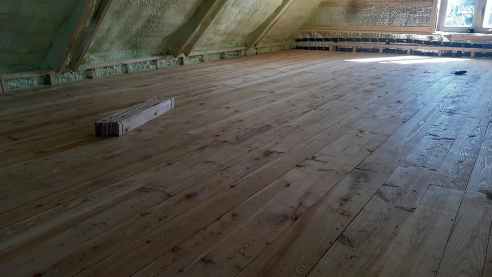 Une pièce avec un plancher en bois et une fenêtre.