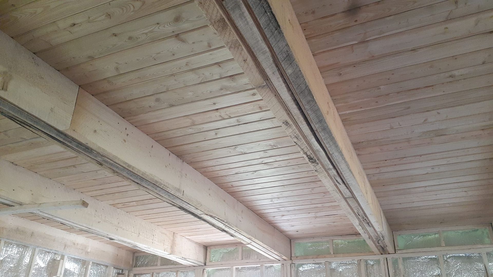 Un gros plan d'un plafond en bois dans un bâtiment en construction.