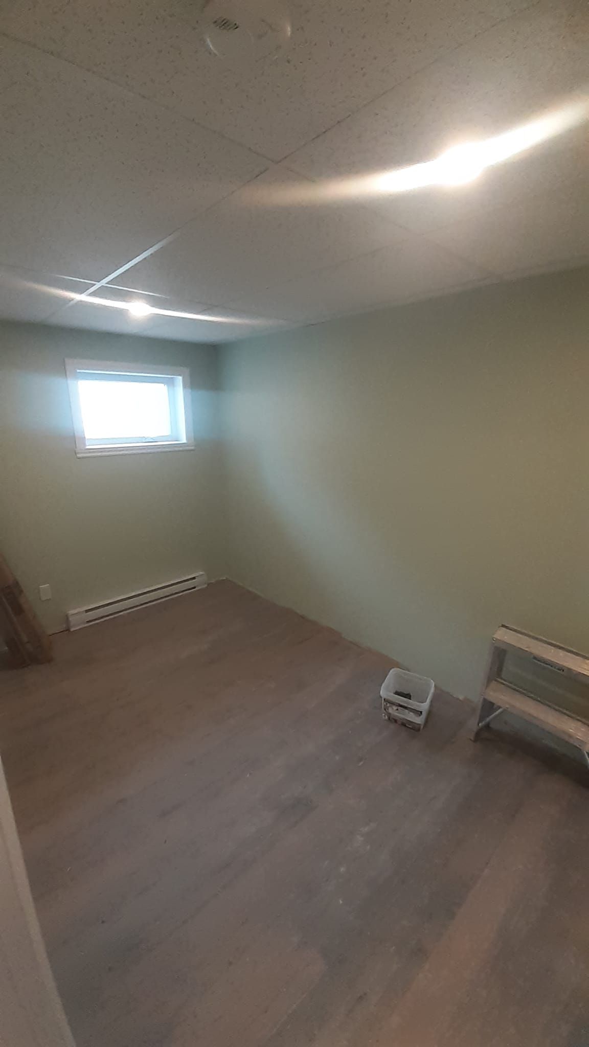 Une pièce vide avec du parquet et une fenêtre.