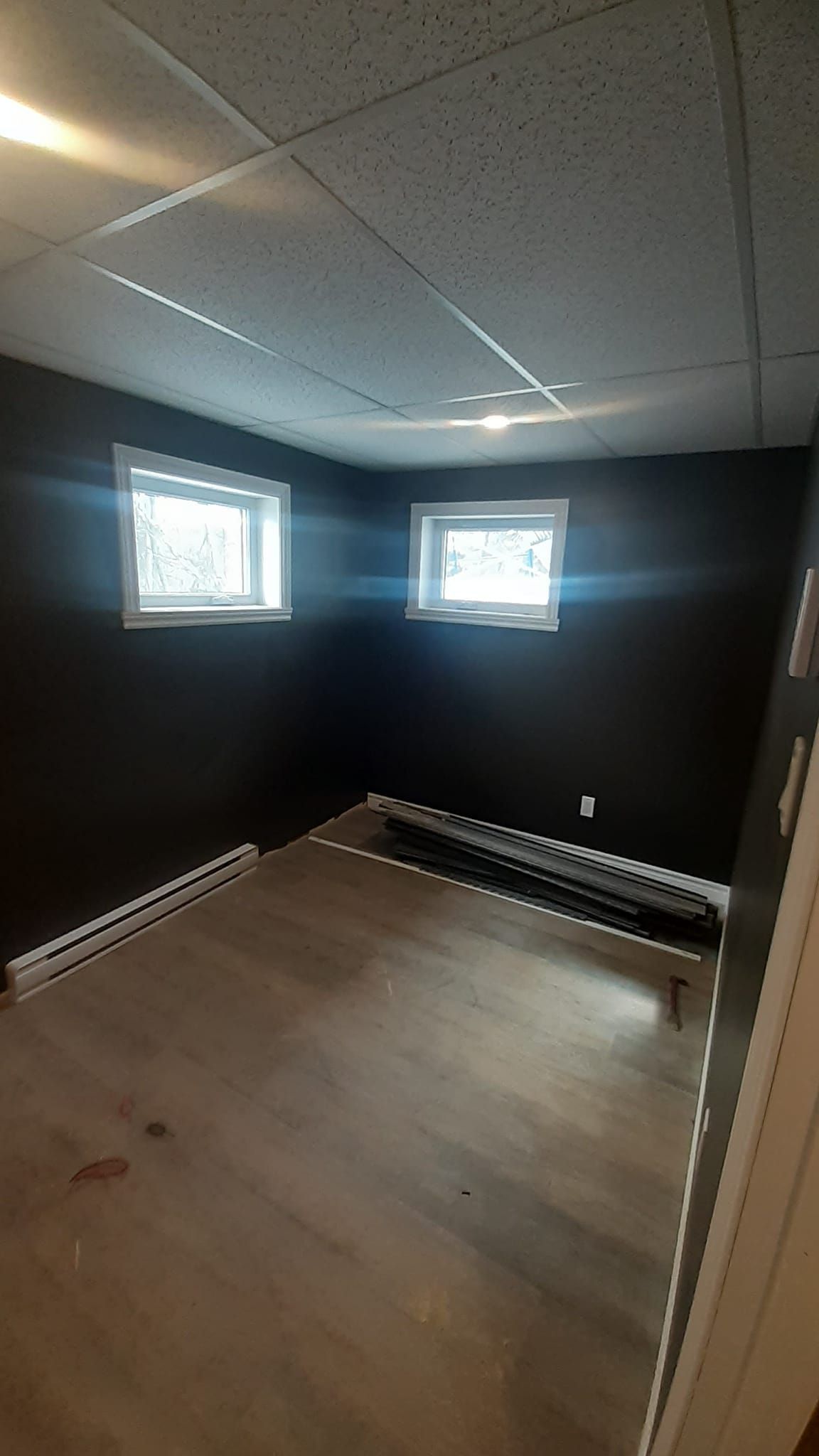 Une pièce vide avec des murs noirs et un plafond blanc.