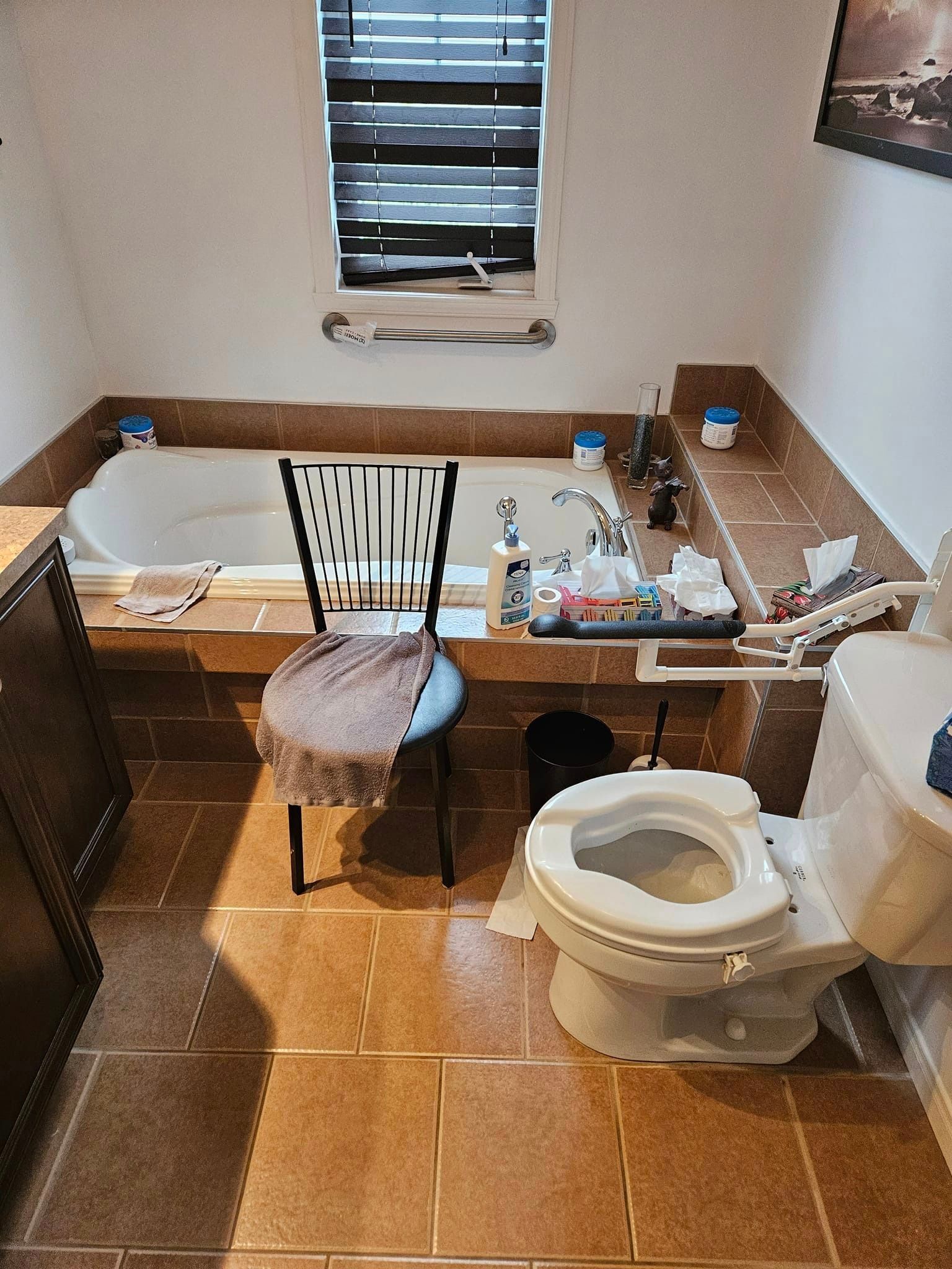 Une salle de bain avec baignoire, toilettes et chaise.