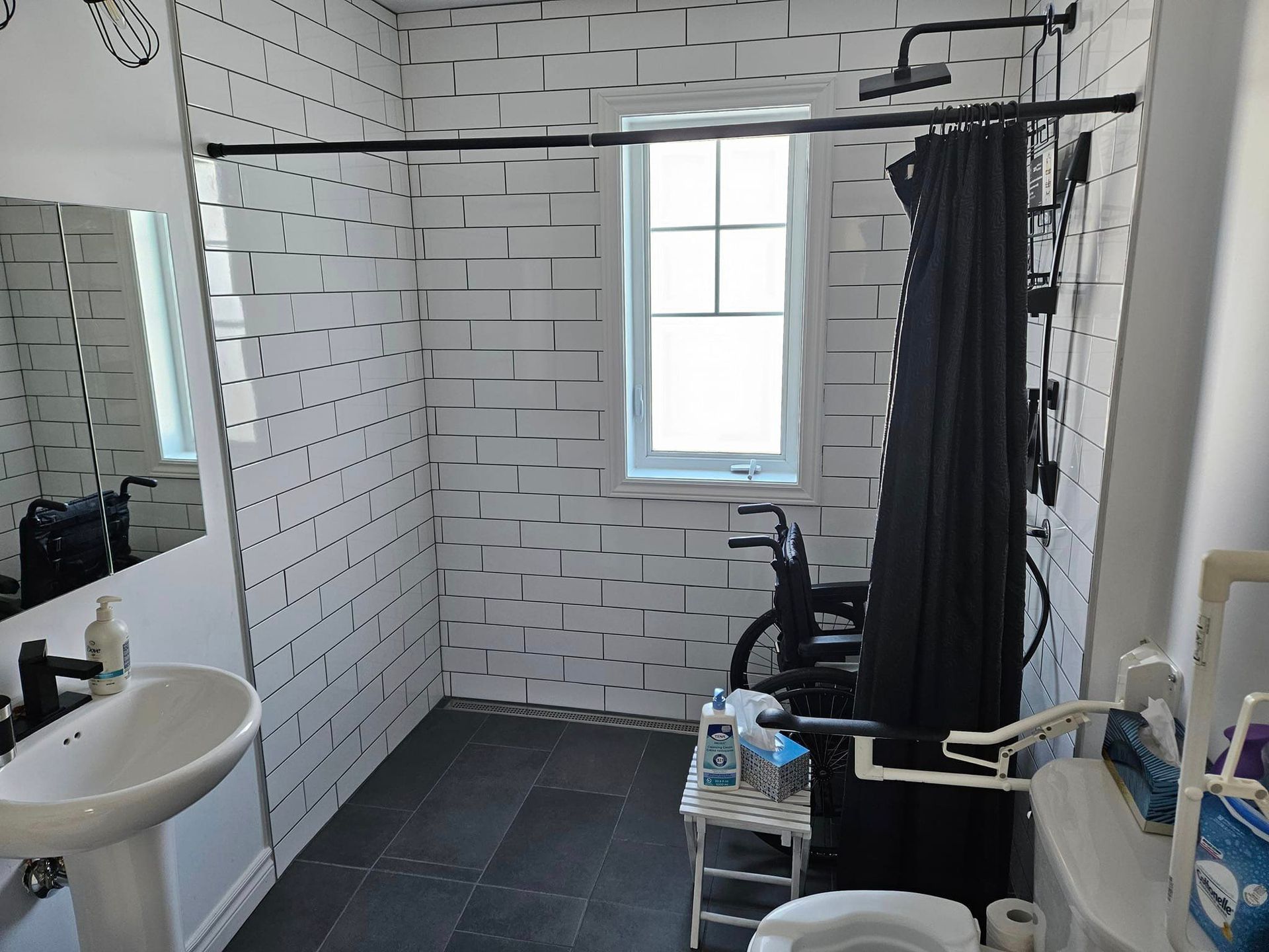 Une salle de bain avec des murs en briques blanches et un rideau de douche noir