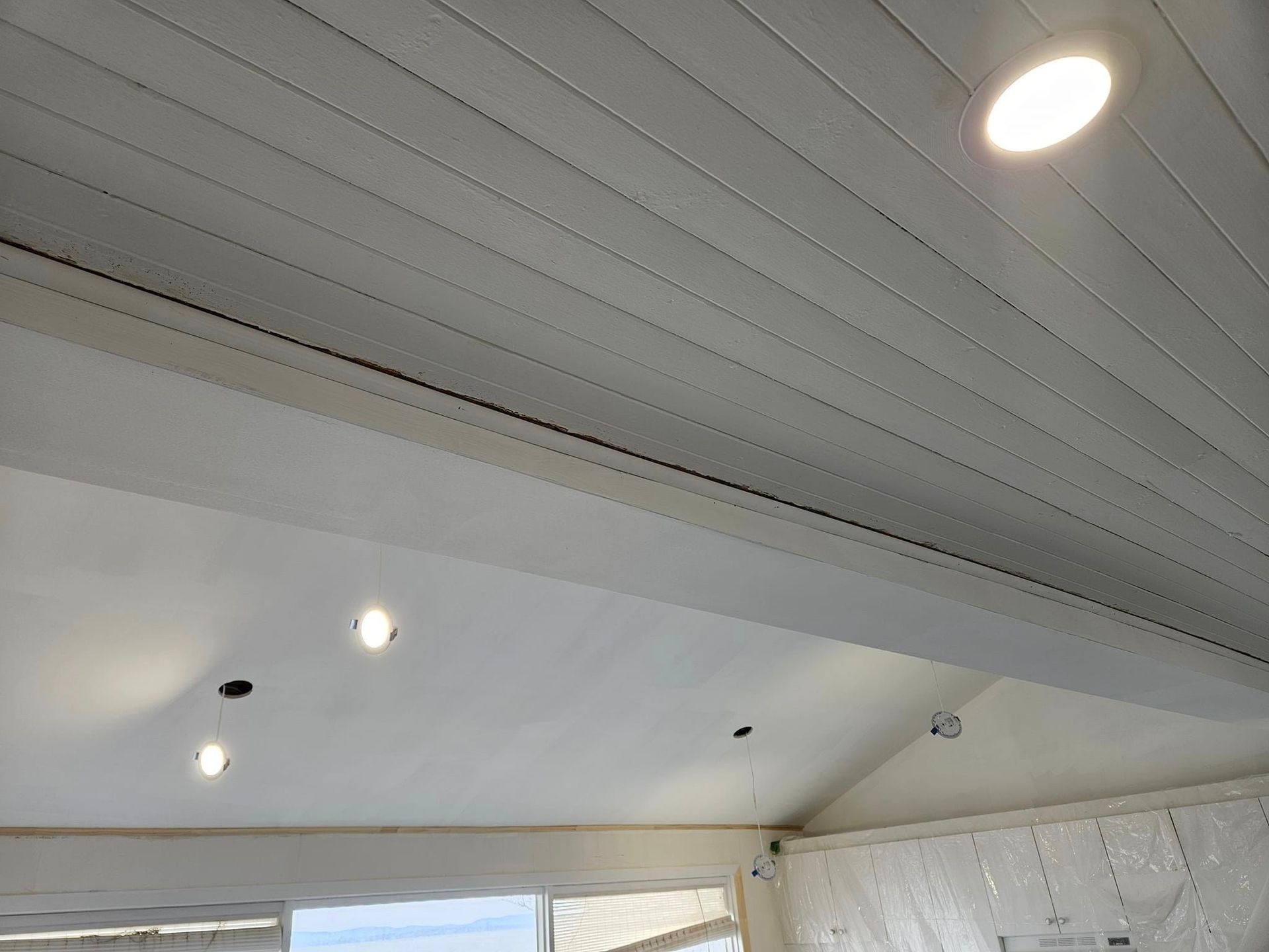 Un plafond blanc avec beaucoup de lumières dans une pièce.