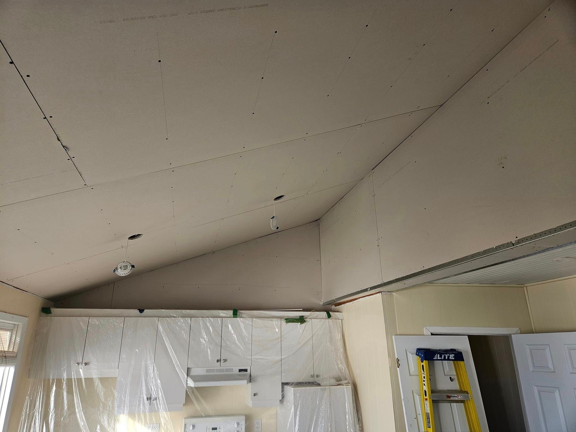 Une échelle est suspendue au plafond d'une pièce en construction