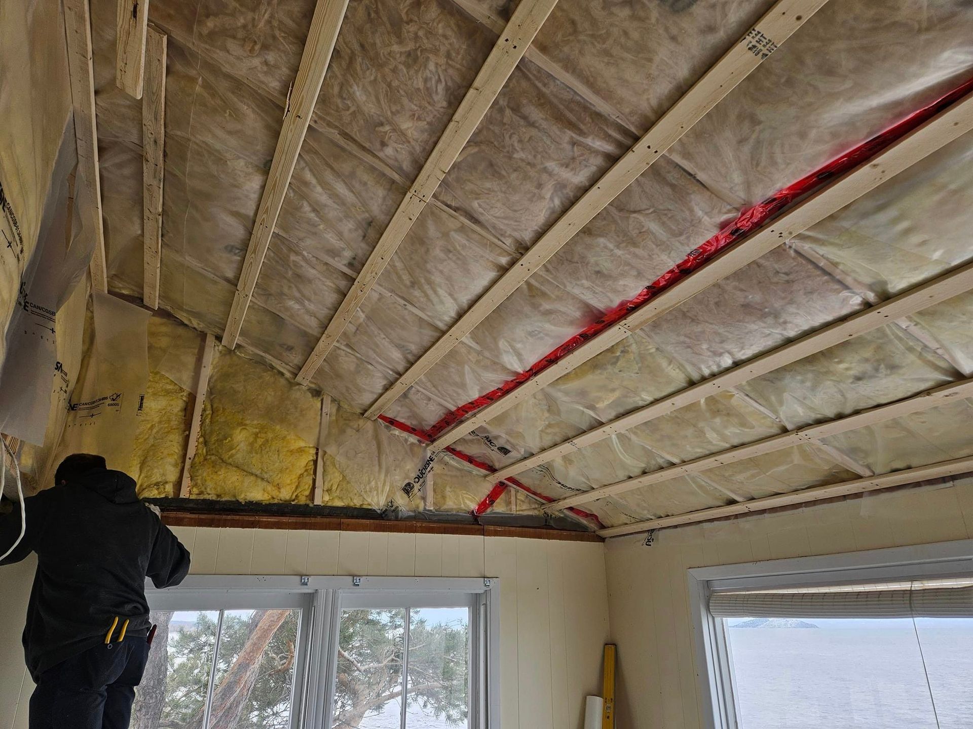 Un homme travaille sur le plafond d'une maison.