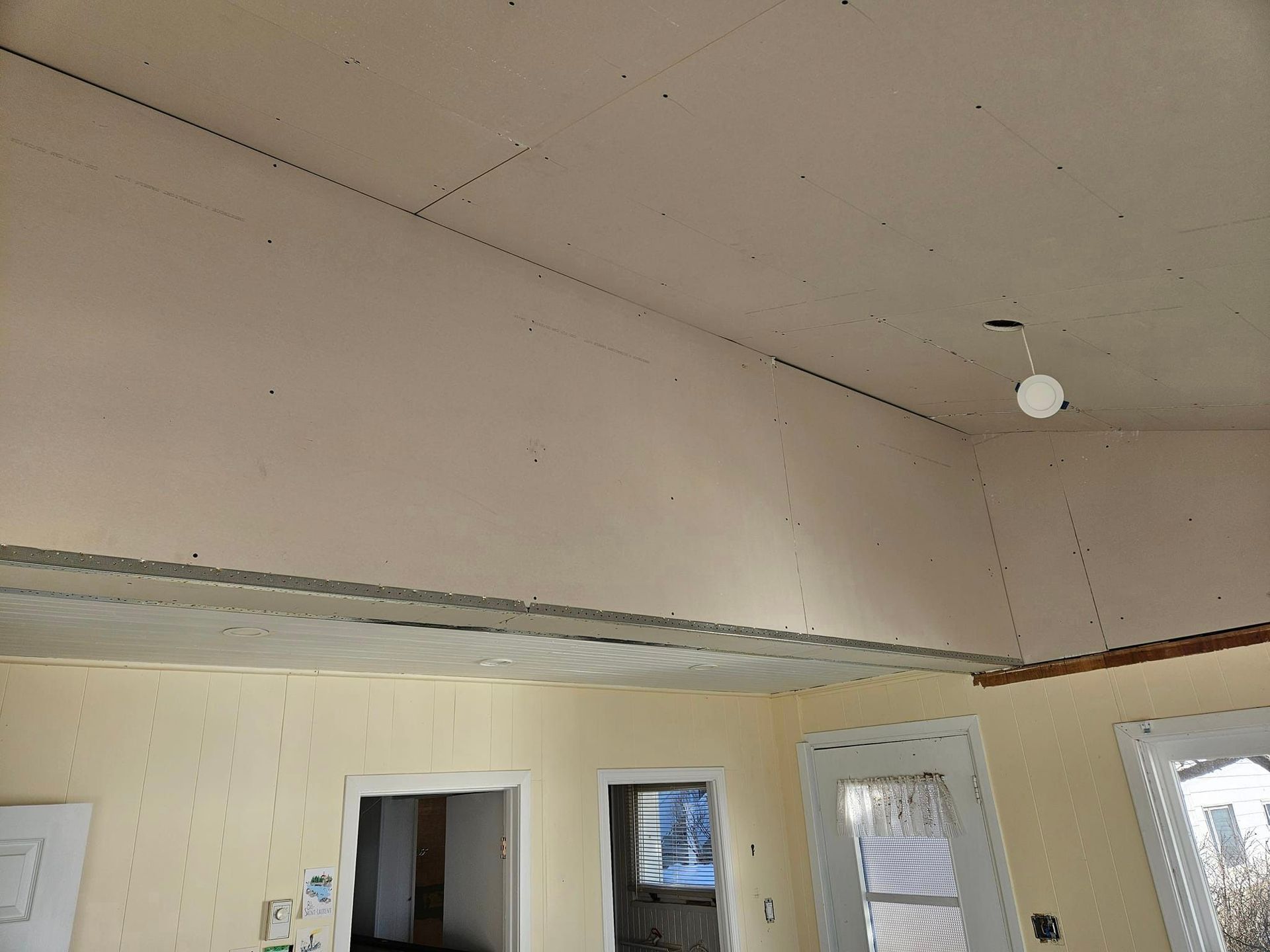 Une pièce avec un plafond voûté et une lumière suspendue au plafond