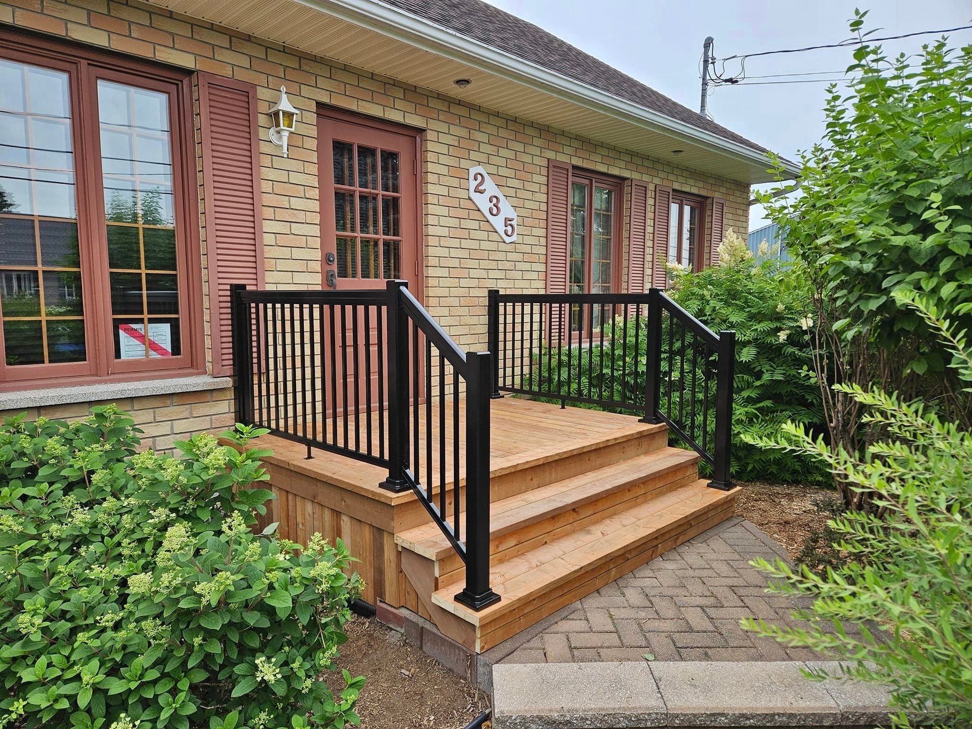 Une maison avec une terrasse en bois et des escaliers devant.