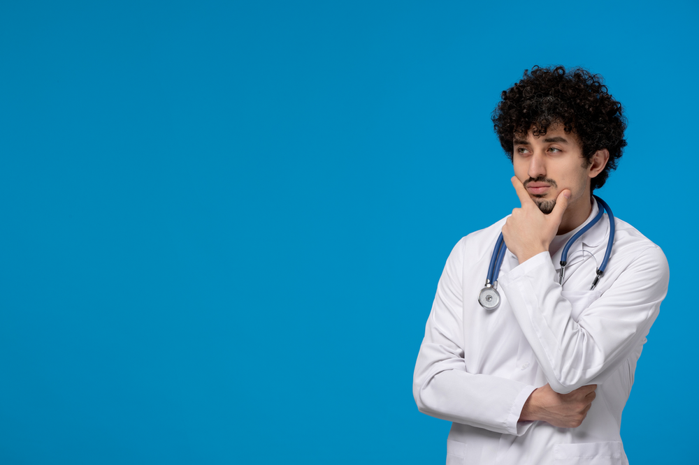 A doctor with a stethoscope around his neck is thinking on a blue background.