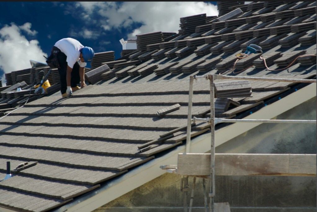 A man is working on the roof of a building