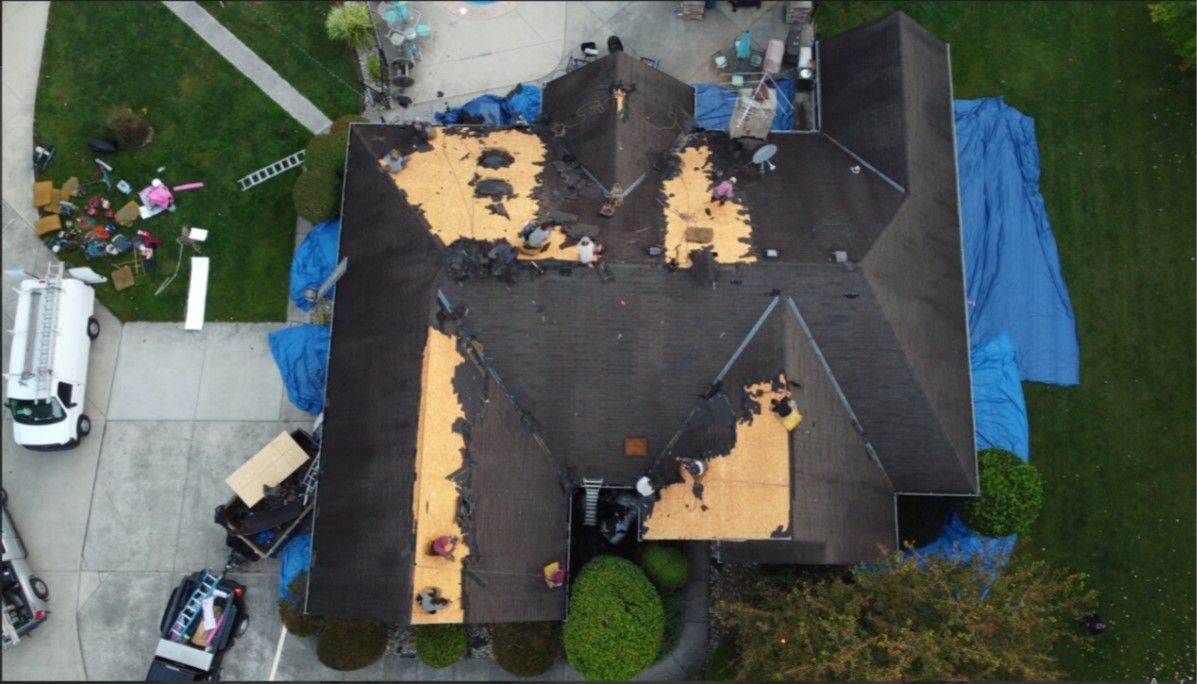 An aerial view of a house with a roof being repaired.