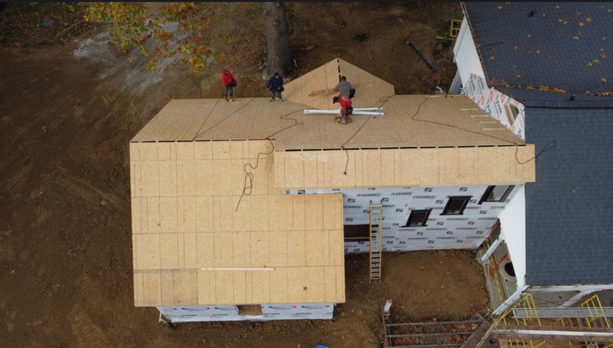 A group of people are working on the roof of a house.