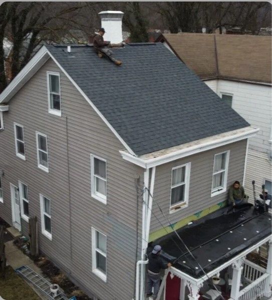 A group of people are working on the roof of a house