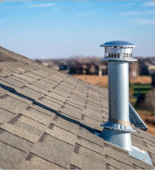 A chimney on top of a roof with a blue sky in the background