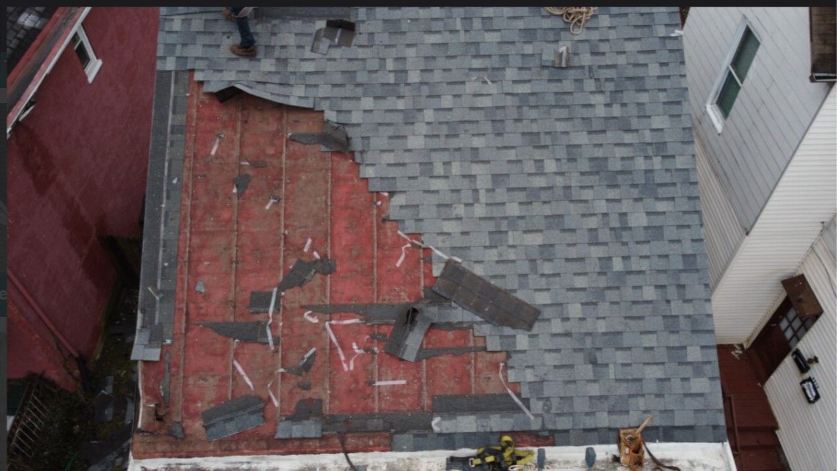 An aerial view of a roof that has been damaged by a storm.