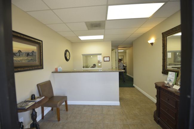 A waiting room at Wolf CPA in Redlands, CA with a bench and a mirror 