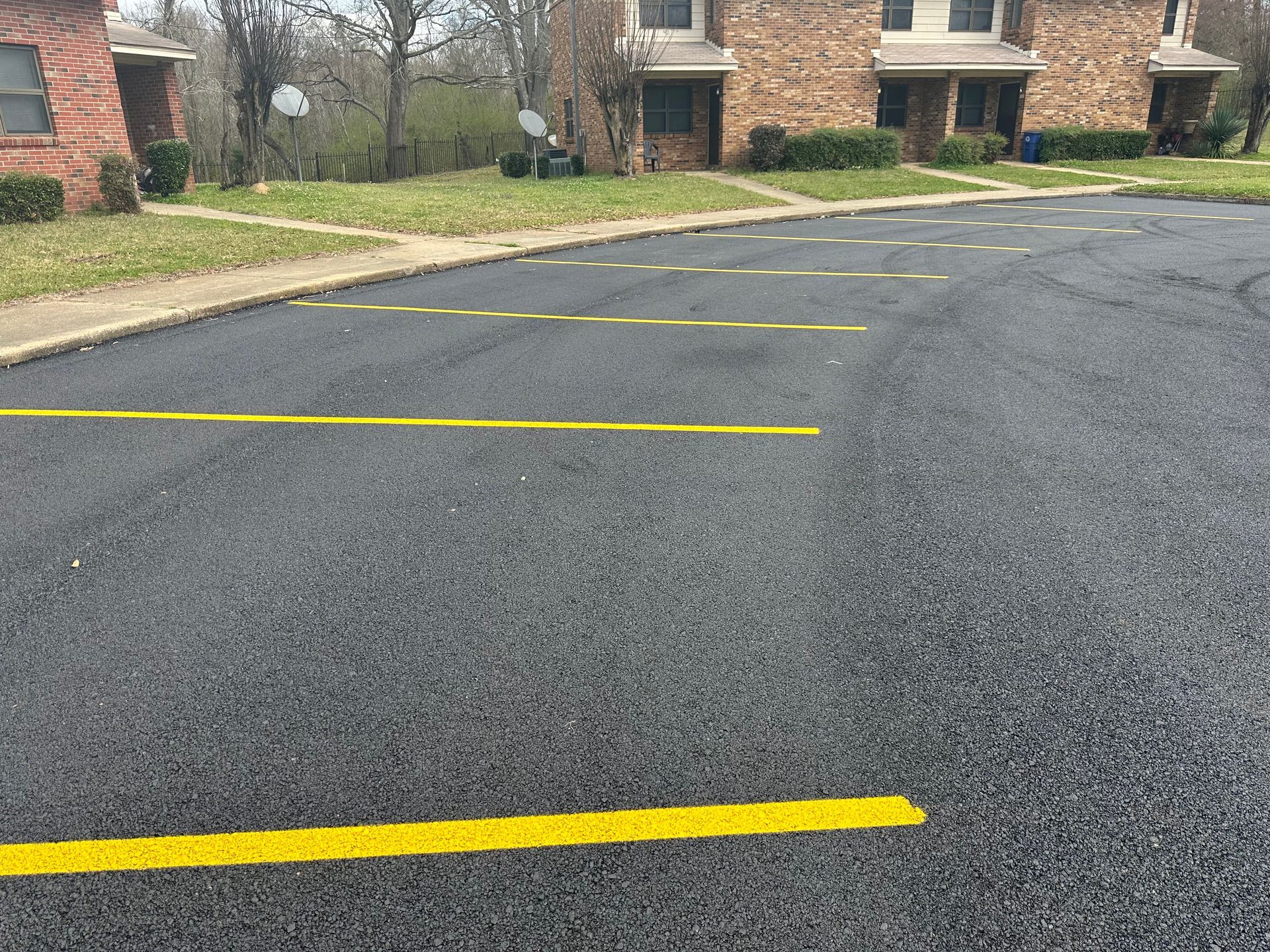 Fresh parking lot striping in St. Louis with bright yellow lines on asphalt, improving visibility, 