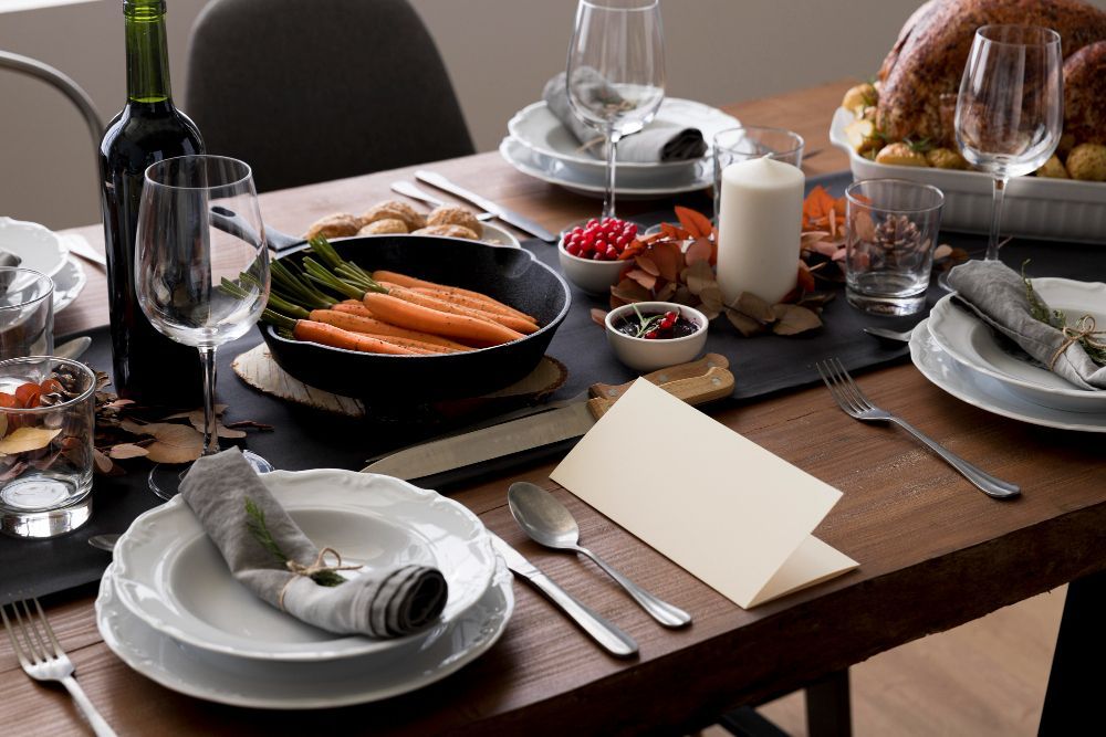 A table set for a thanksgiving dinner with plates , utensils , and a turkey on it.