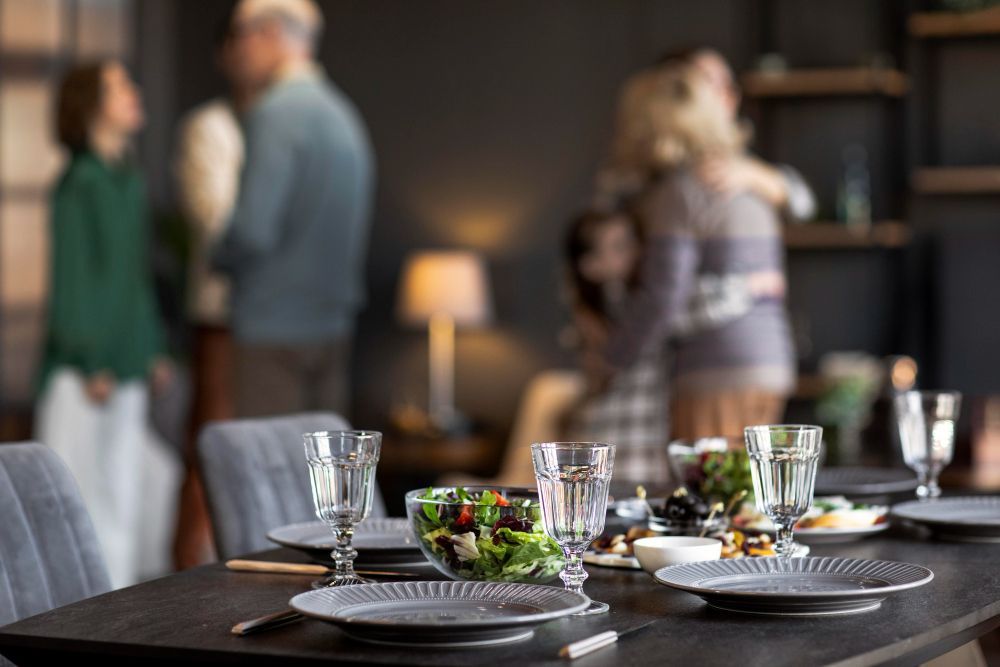 A table set for a dinner party with people dancing in the background.