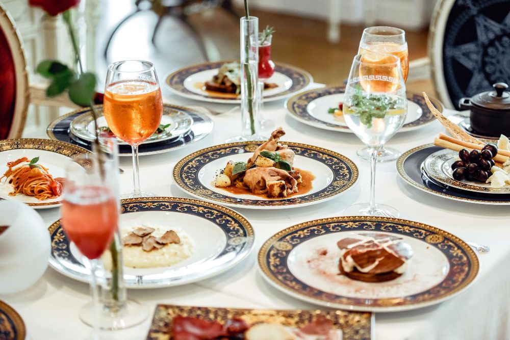 A table topped with plates of food and wine glasses.