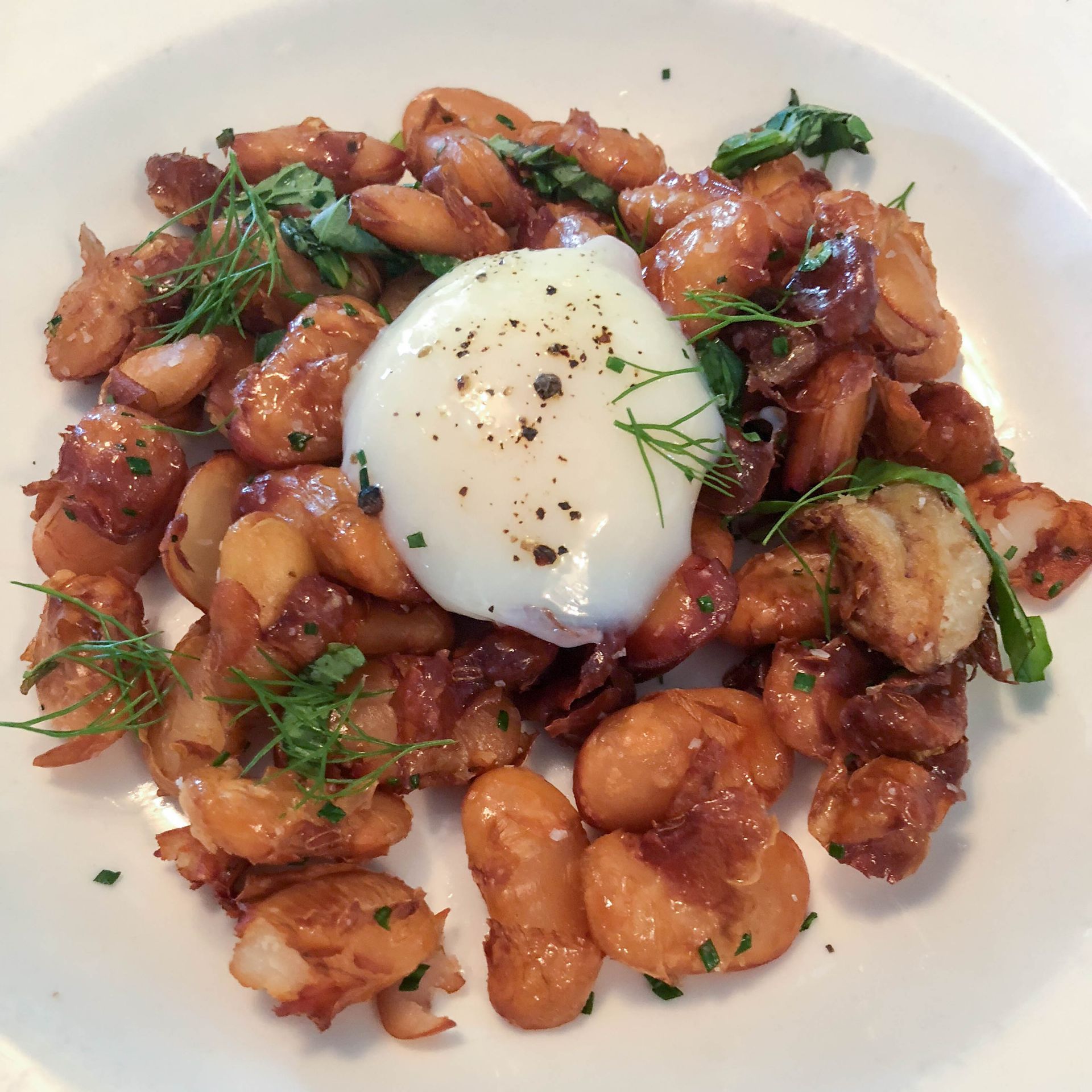 A plate of food with a poached egg on top