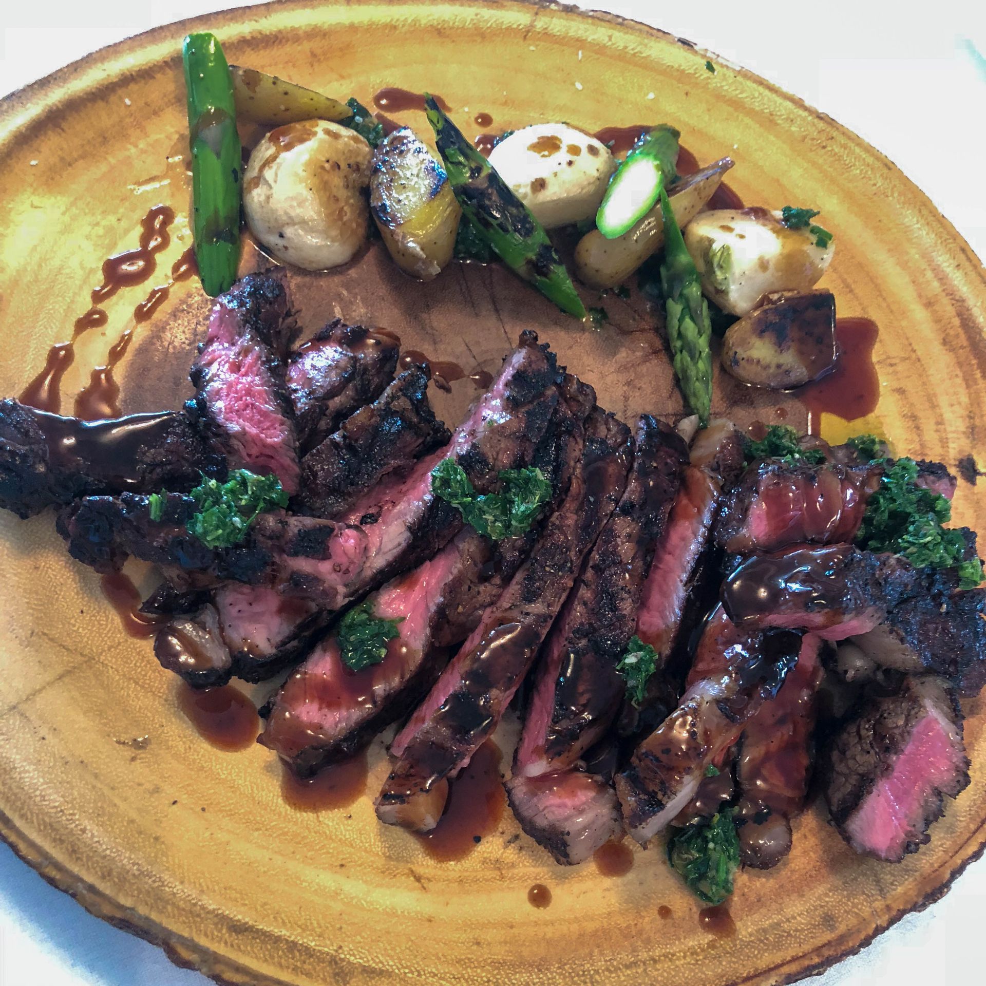 A plate of meat and vegetables on a wooden cutting board