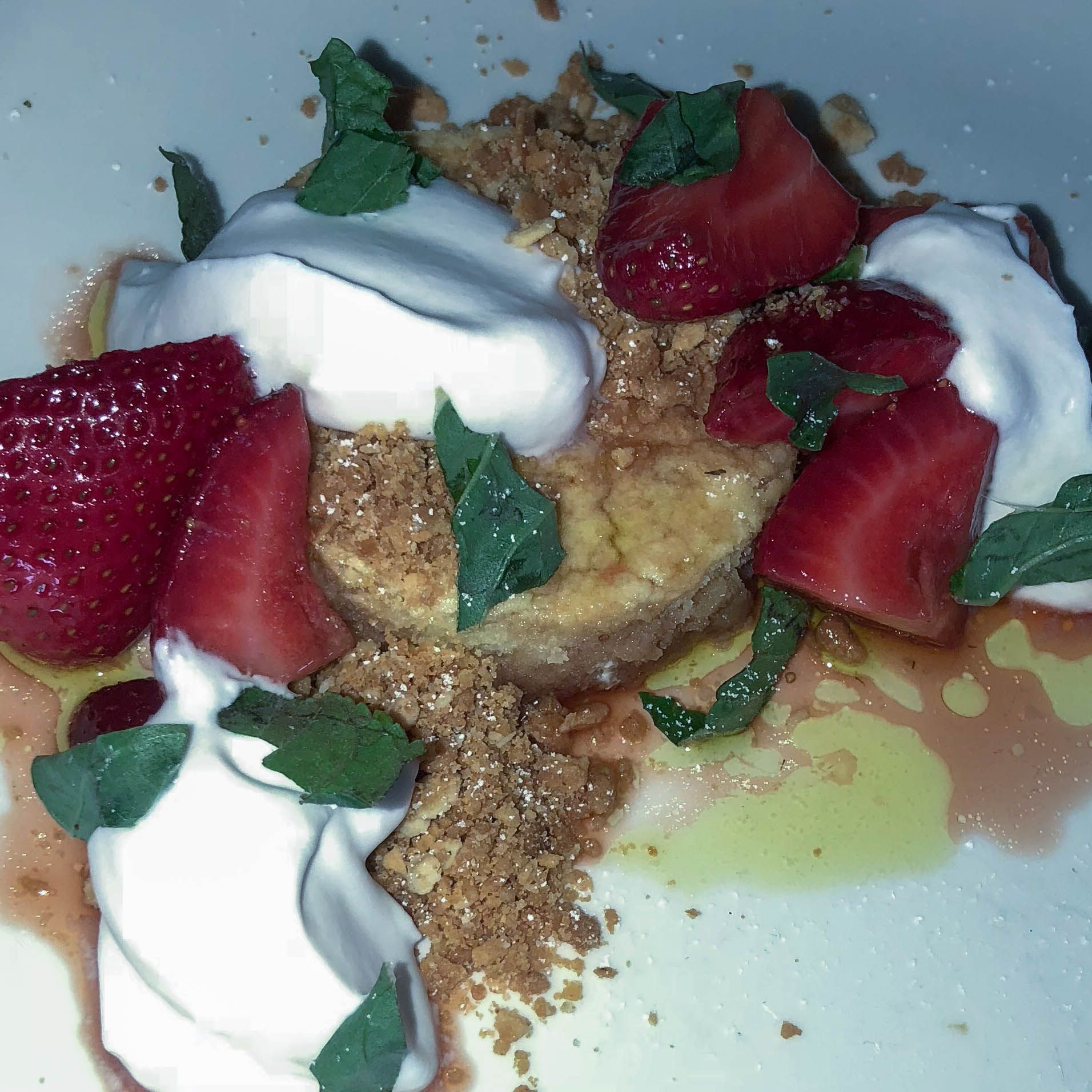 A close up of a dessert with strawberries and whipped cream