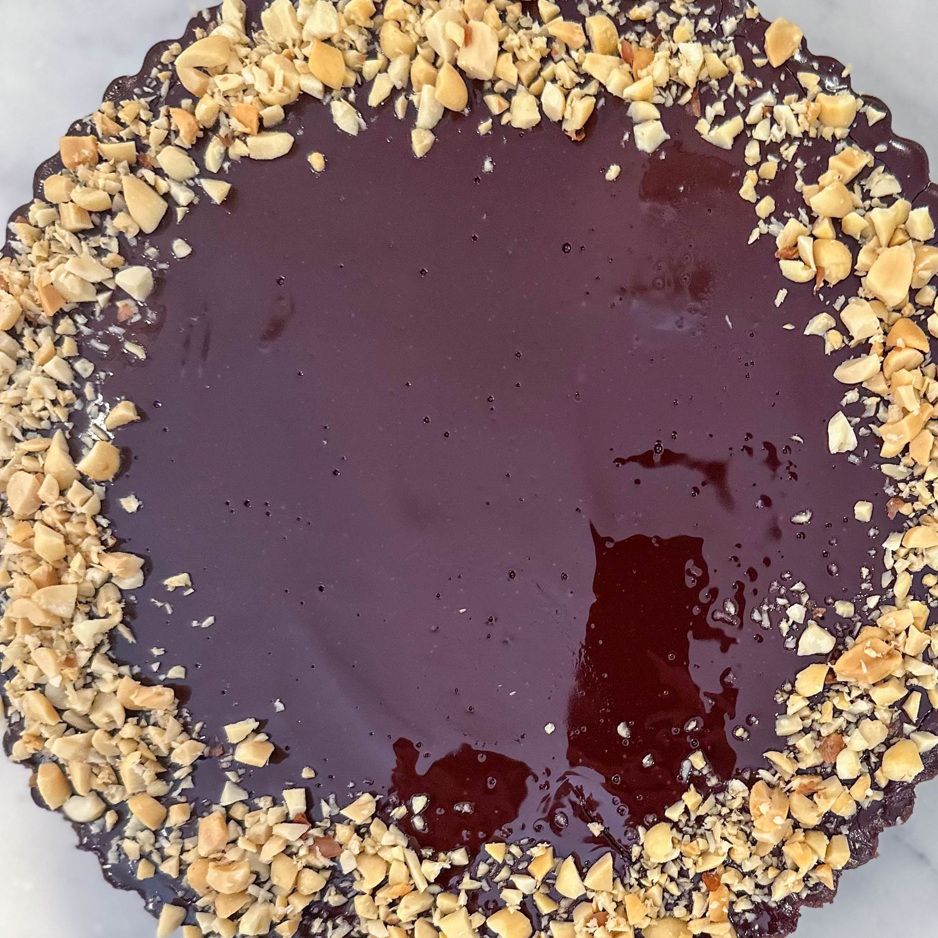 A chocolate cake with peanuts on top of it