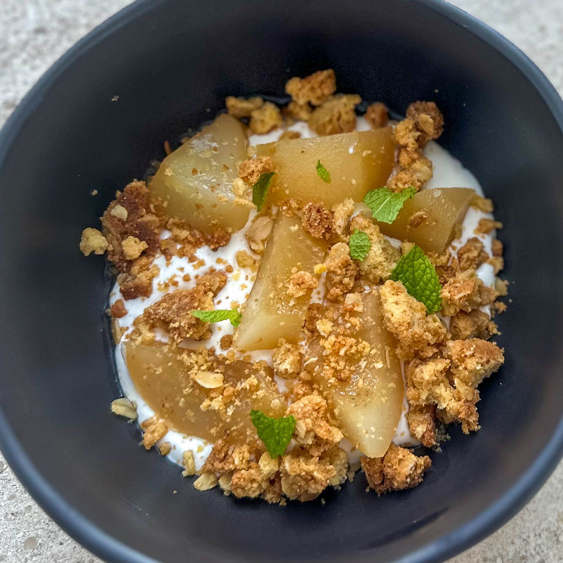 A close up of a bowl of food with a crumb topping