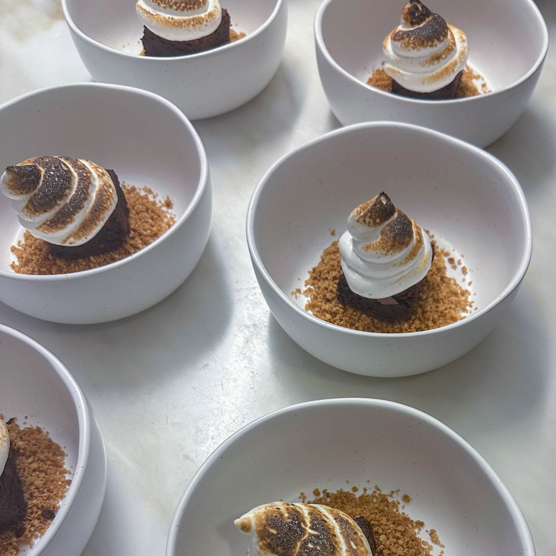 A bunch of bowls filled with desserts on a table