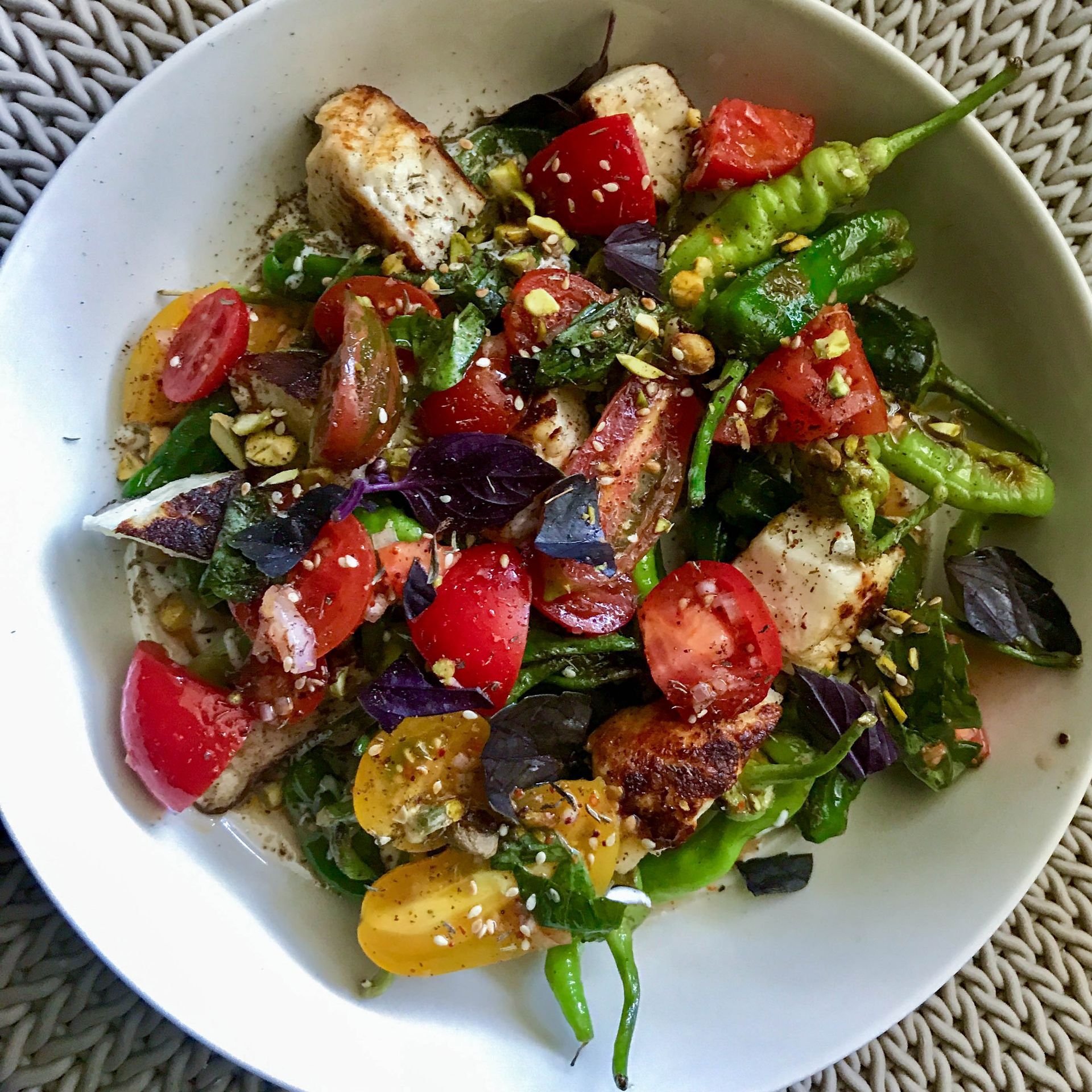 A salad with tomatoes and green peppers on a white plate
