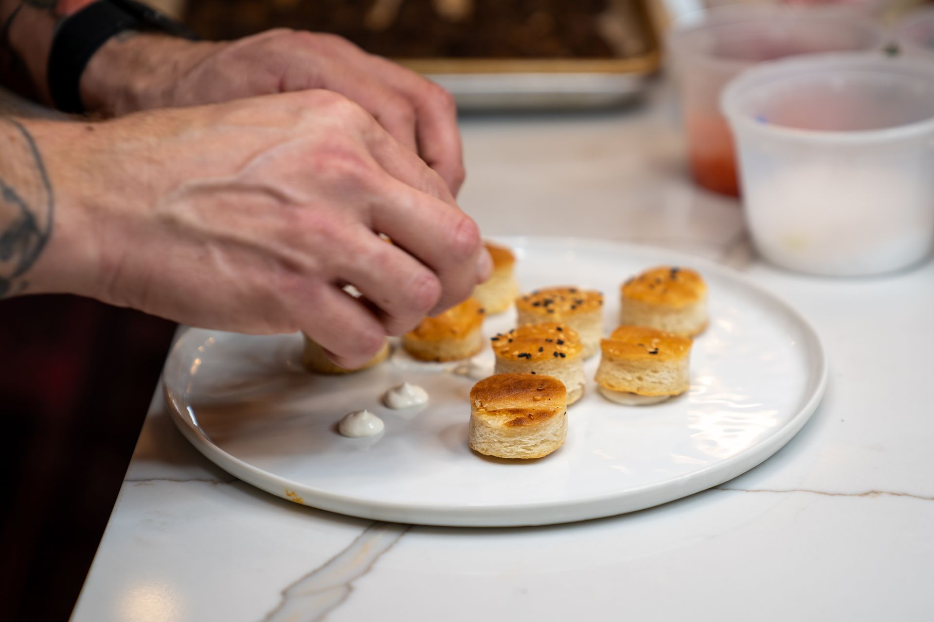 A person is preparing food on a plate on a table.