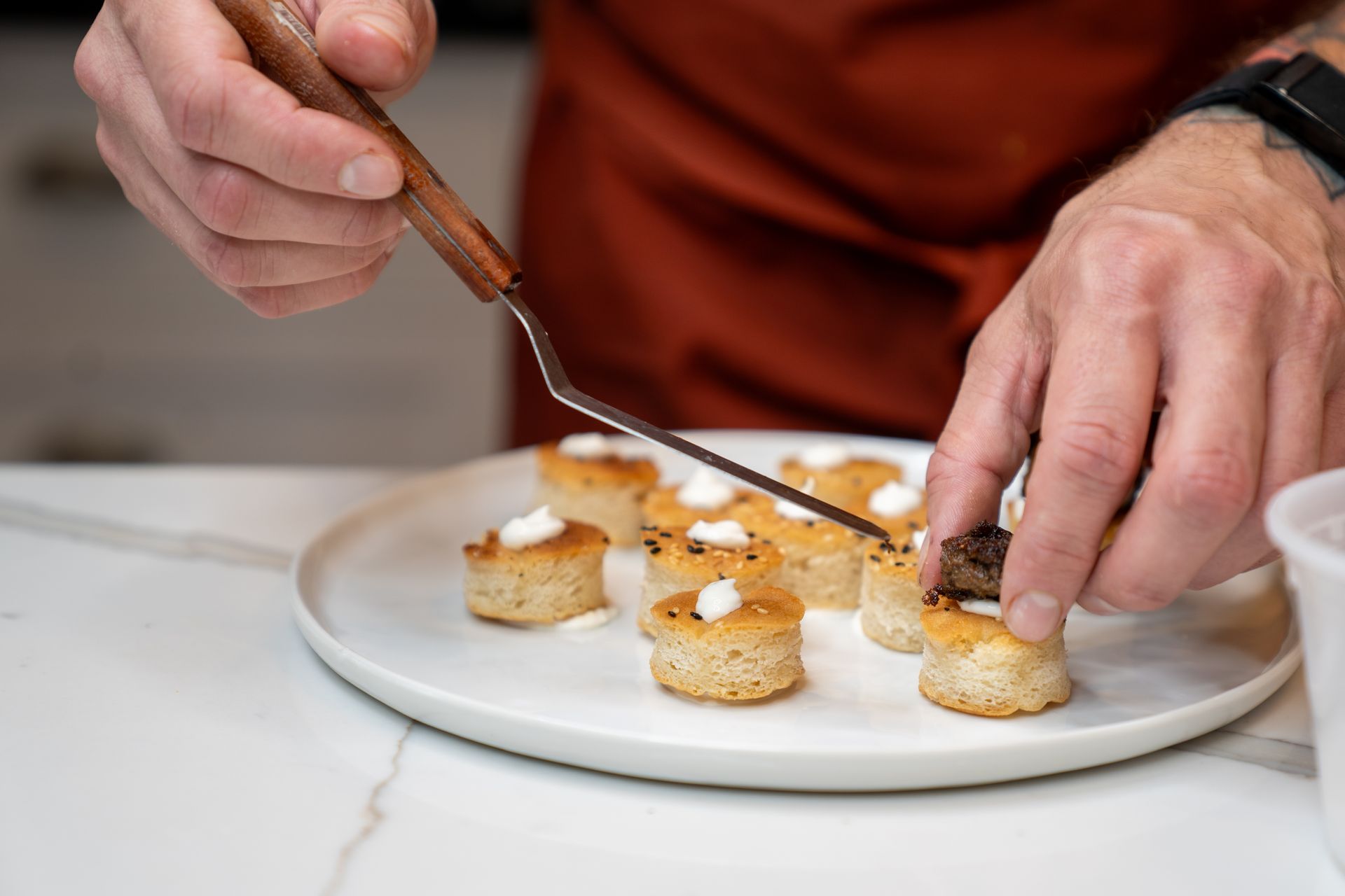 A person is cutting a piece of food on a plate with a fork.