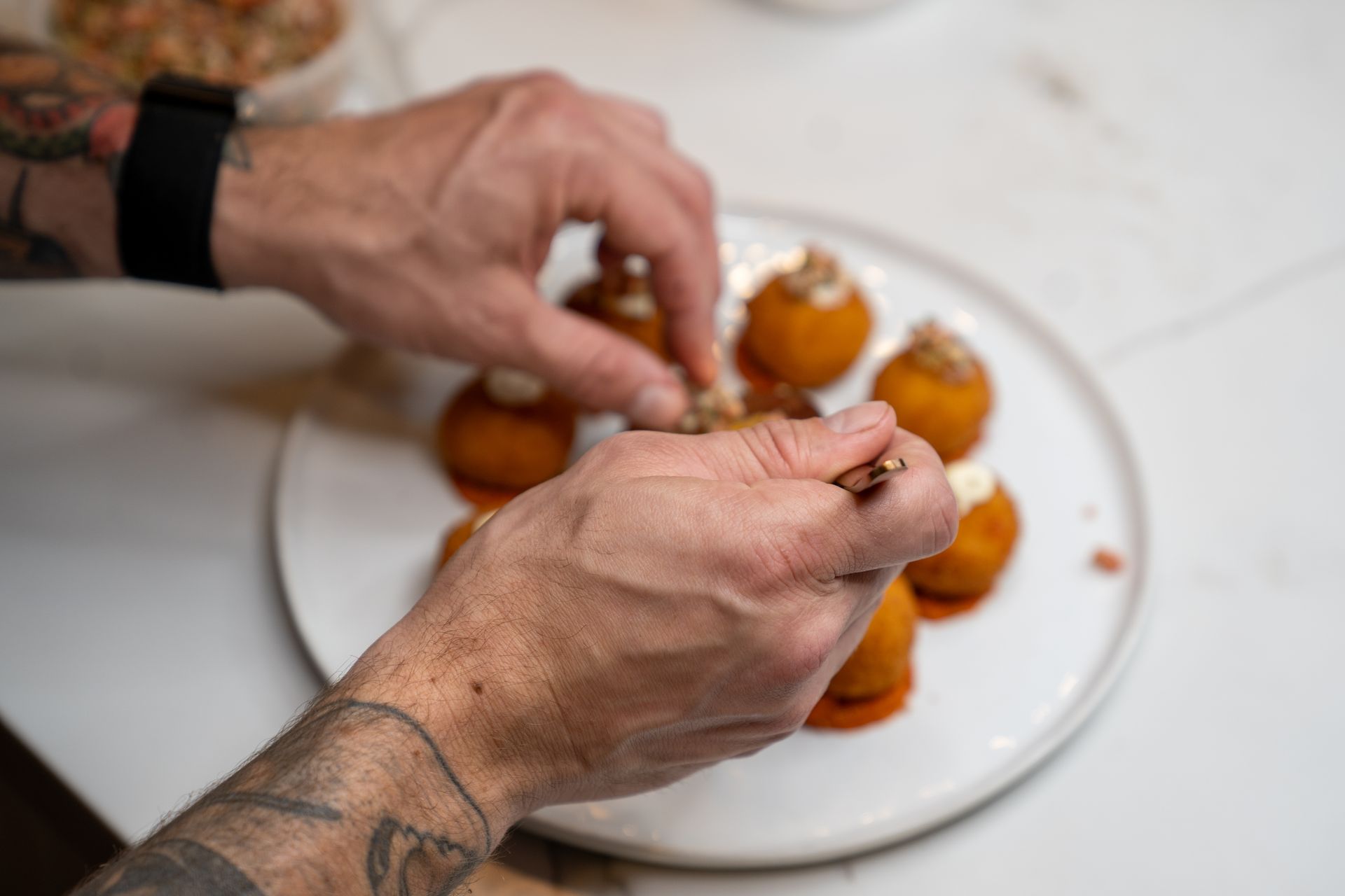 A close up of a person 's hands preparing food on a plate.