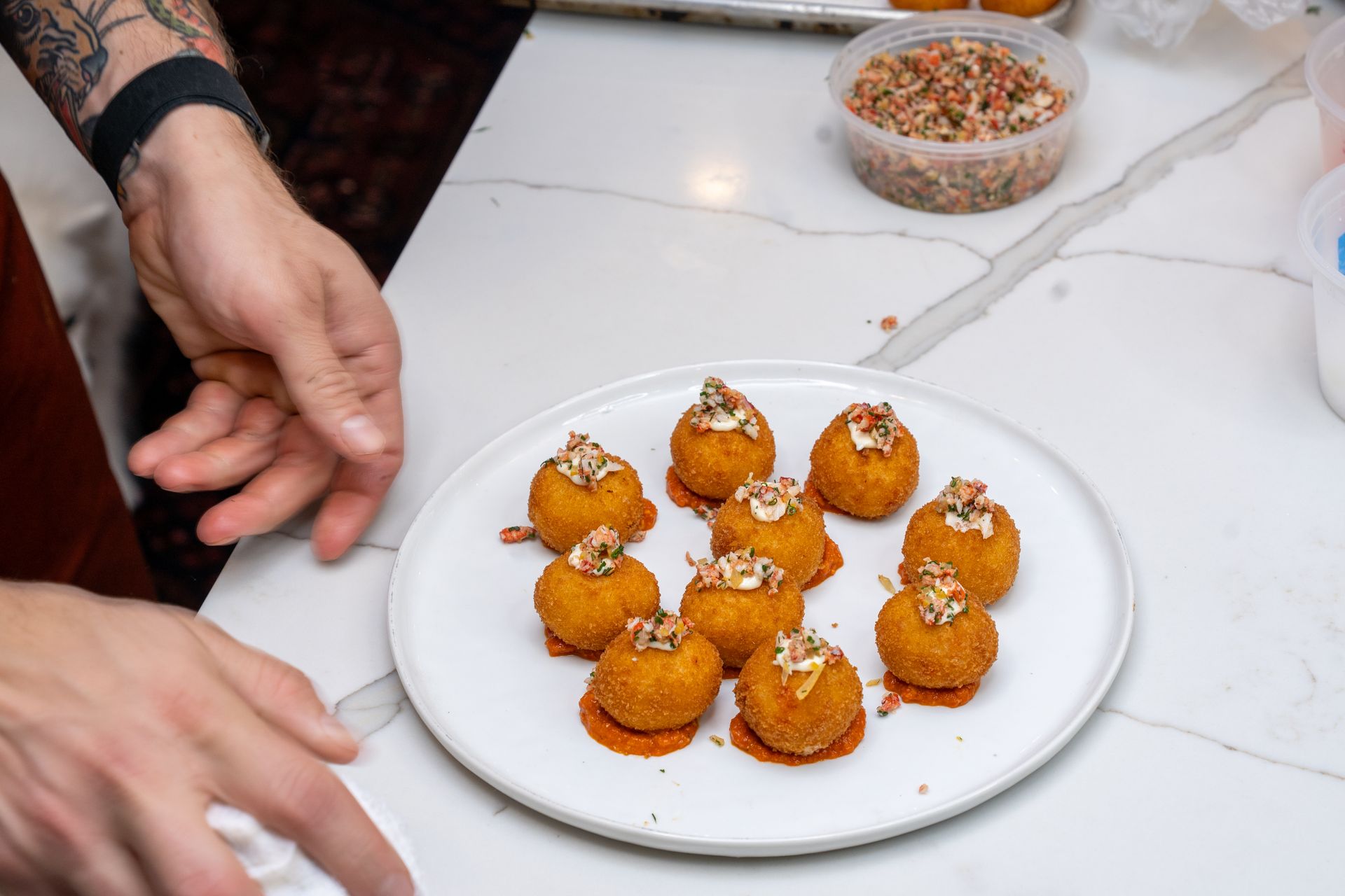 A person is preparing a plate of food on a counter.