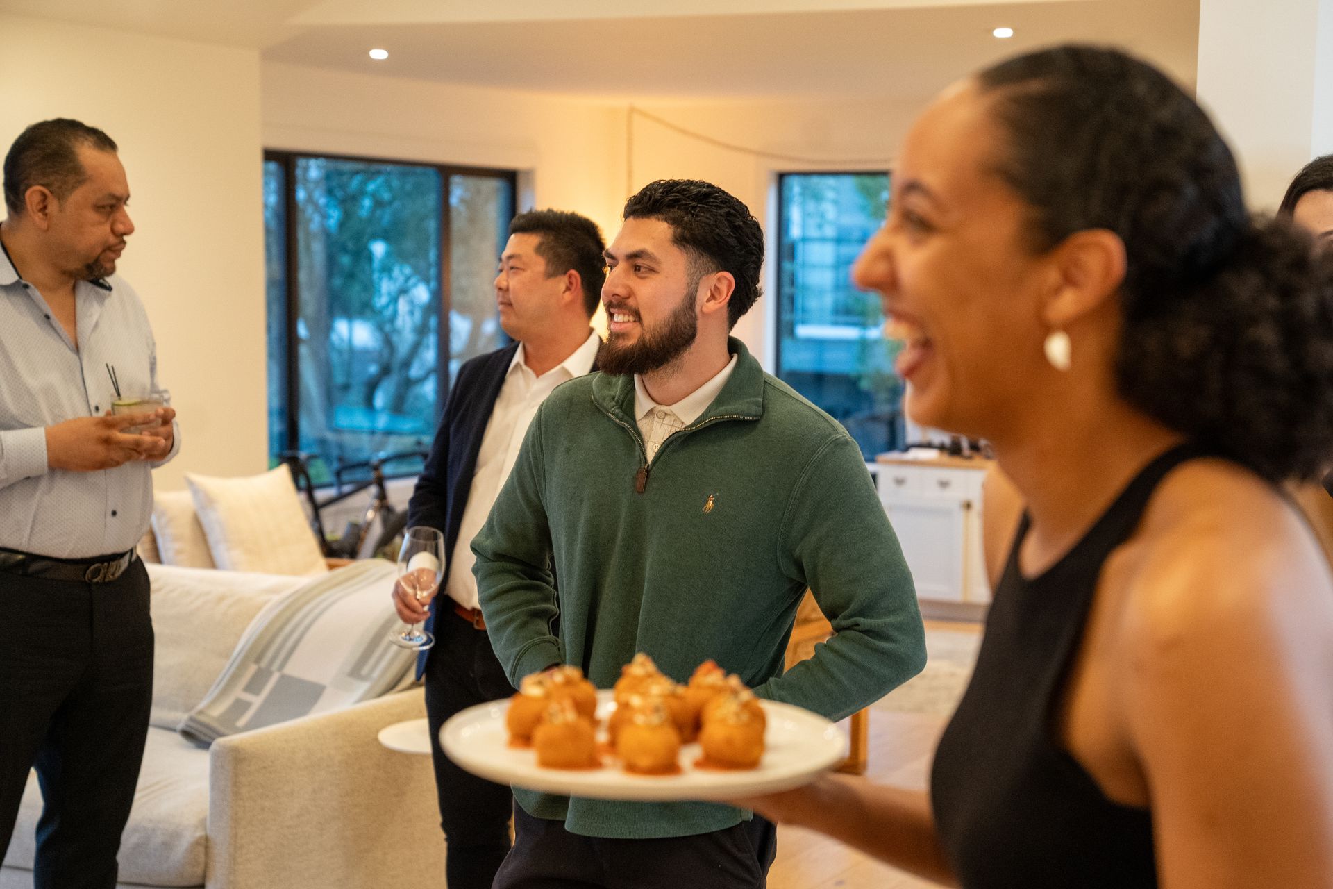 A woman is holding a plate of food in front of a group of people.