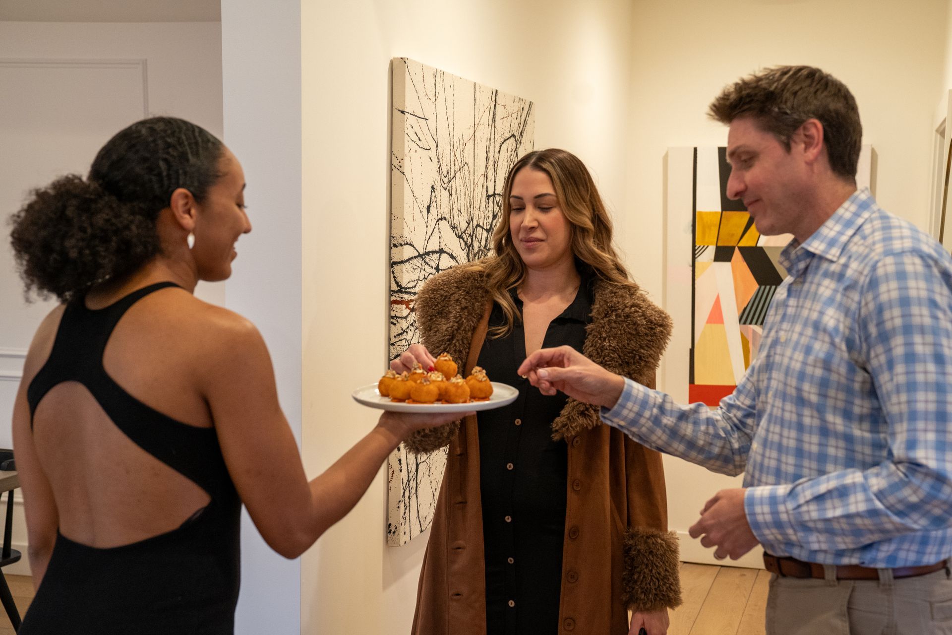 A woman is holding a plate of food in front of a group of people.